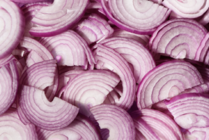 A close up of thinly sliced red onion showing the vibrant color and freshness.